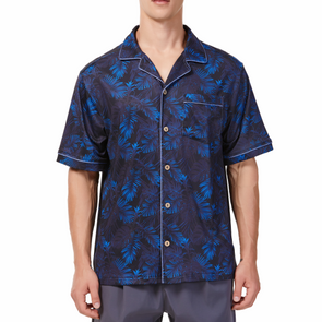 Men's Short sleeve black and blue all over palm frond printed camp shirt in a relaxed fit with a chest pocket made from knit fabric on a model - front view