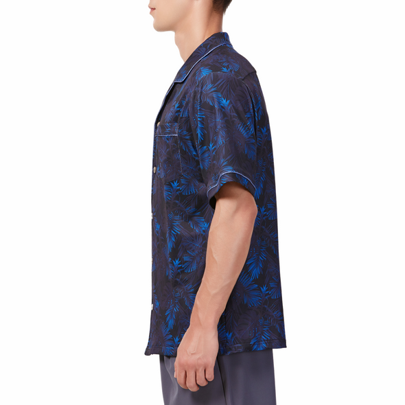 Men's Short sleeve black and blue all over palm frond printed camp shirt in a relaxed fit with a chest pocket made from knit fabric on a model - side view
