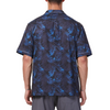 Men's Short sleeve black and blue all over palm frond printed camp shirt in a relaxed fit with a chest pocket made from knit fabric on a model - back view