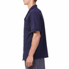 Men's Short sleeve navy camp shirt in a relaxed fit with a chest pocket made from knit fabric on a model - side view