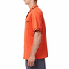 Men's Short sleeve orange camp shirt in a relaxed fit with a chest pocket made from knit fabric on a model - side view