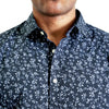 close up view of the collar and neck area of woven button up shirt in a navy floral pattern on a black male model