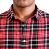 close up view of the pointed collar and neck area of flannel button up shirt in red plaid on a black male model