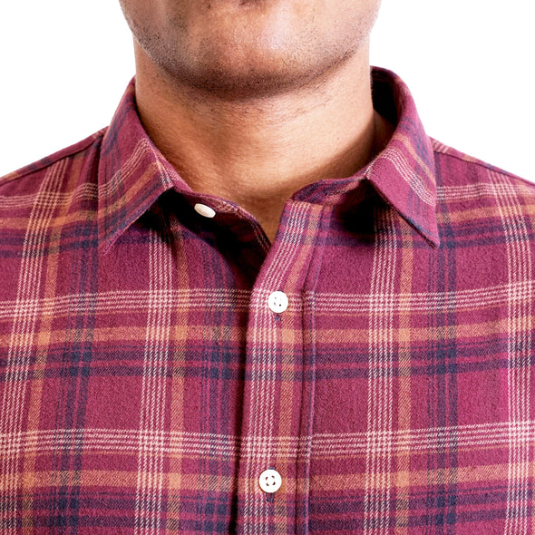 close up view of the pointed collar and neck area of flannel button up shirt in maroon plaid on a black male model
