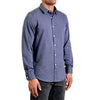 Three quarters side view of men's long sleeve, slim fit, classicnavy button up shirt on a black model.