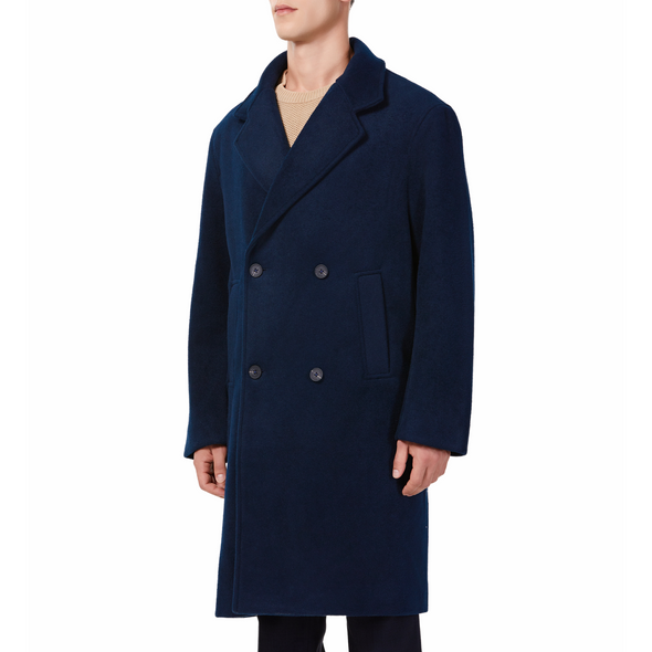 Men's long sleeve navy wool blend overcoat with double breasted front closure, large welt waist pockets and slightly oversized on a model - quarter view