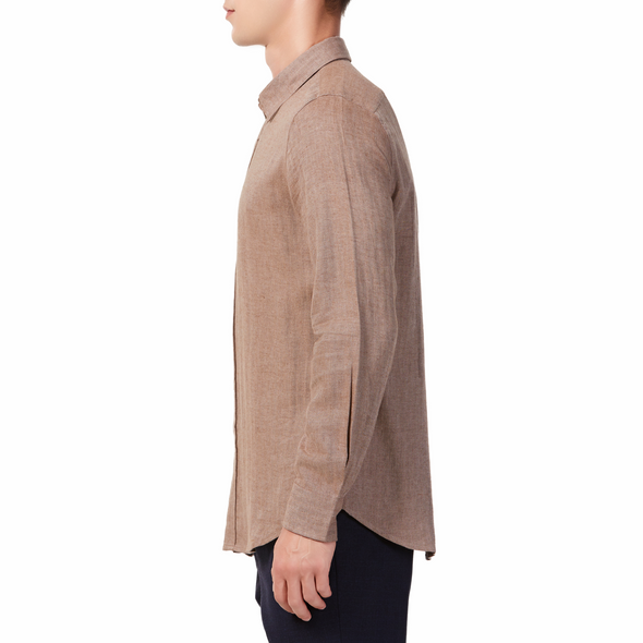 Men's brown linen long sleeve button up shirt with a pointed collar on a model. Image is cropped to the torso and model is facing to the side so the arm is facing the viewer