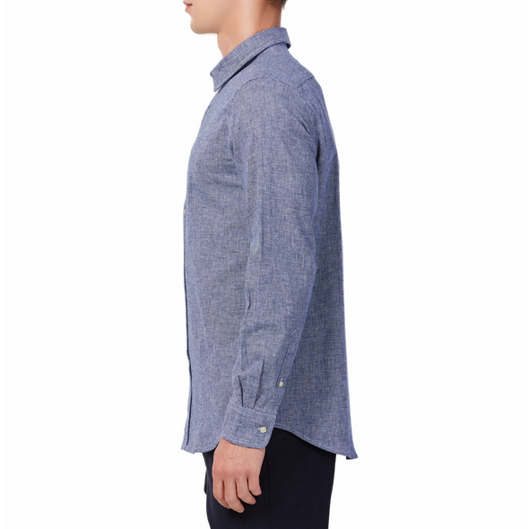 Men's  navy and white mini houndstooth patterned linen blend,  long sleeve button up shirt with a pointed collar on a model. Image is cropped to the torso and model is facing to the side so the arm is facing the viewer