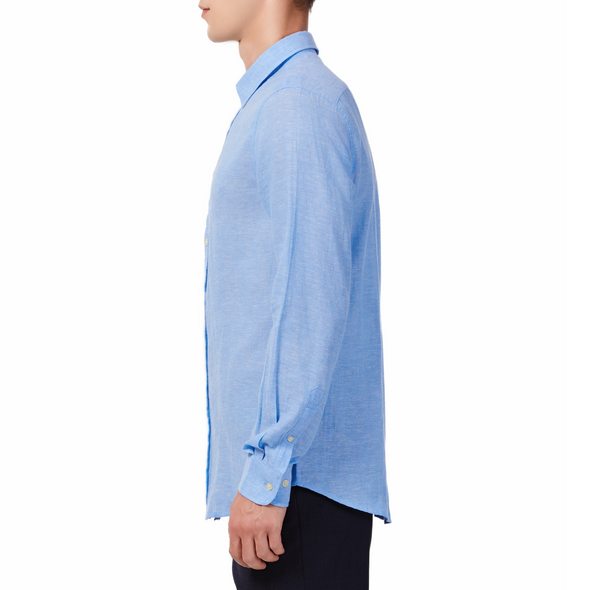 Men's bright blue linen long sleeve button up shirt with a pointed collar on a model. Image is cropped to the torso and model is facing to the side so the arm is facing the viewer