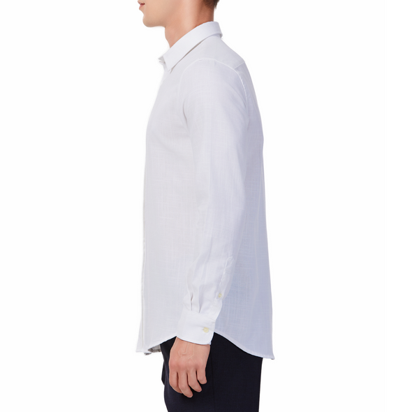 Men's white textured linen long sleeve button up shirt with a pointed collar on a model. Image is cropped to the torso and model is facing to the side so the arm is facing the viewer