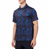 Men's Short sleeve polo shirt in a blue and black allover palm frond print. Has a 3 button front colosure and pointed blue collar made from knit fabric on a model - quarter view