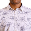close up view of the pointed collar and neck area of cotton fabric button up shirt in a navy floral pattern on white ground. Worn by a black male model. The top buttons are undone